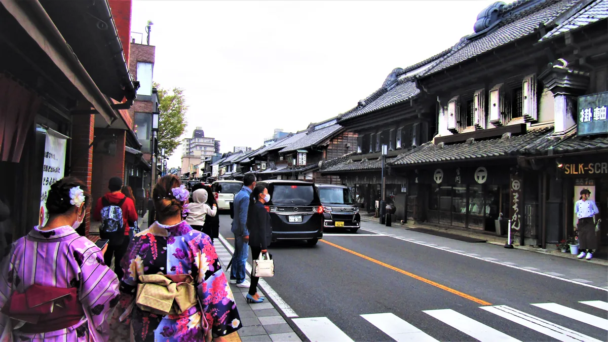 伝統的な店蔵や車が見える川越の通り