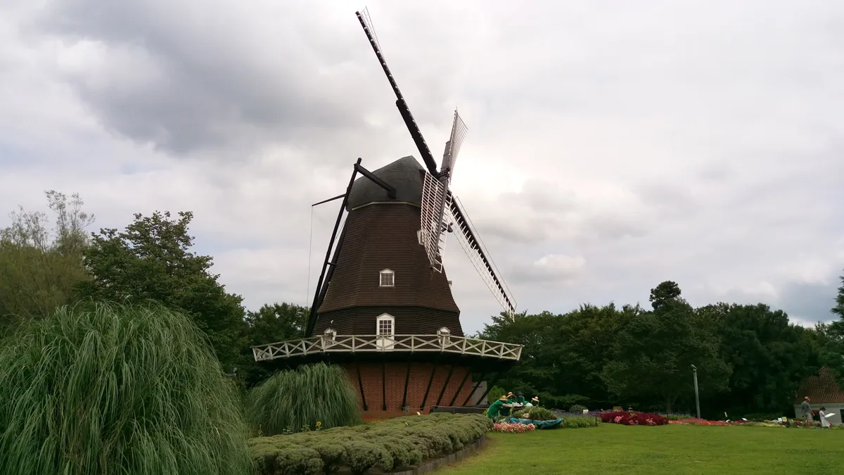 A wooden windmill and flower beds in Andersen Park