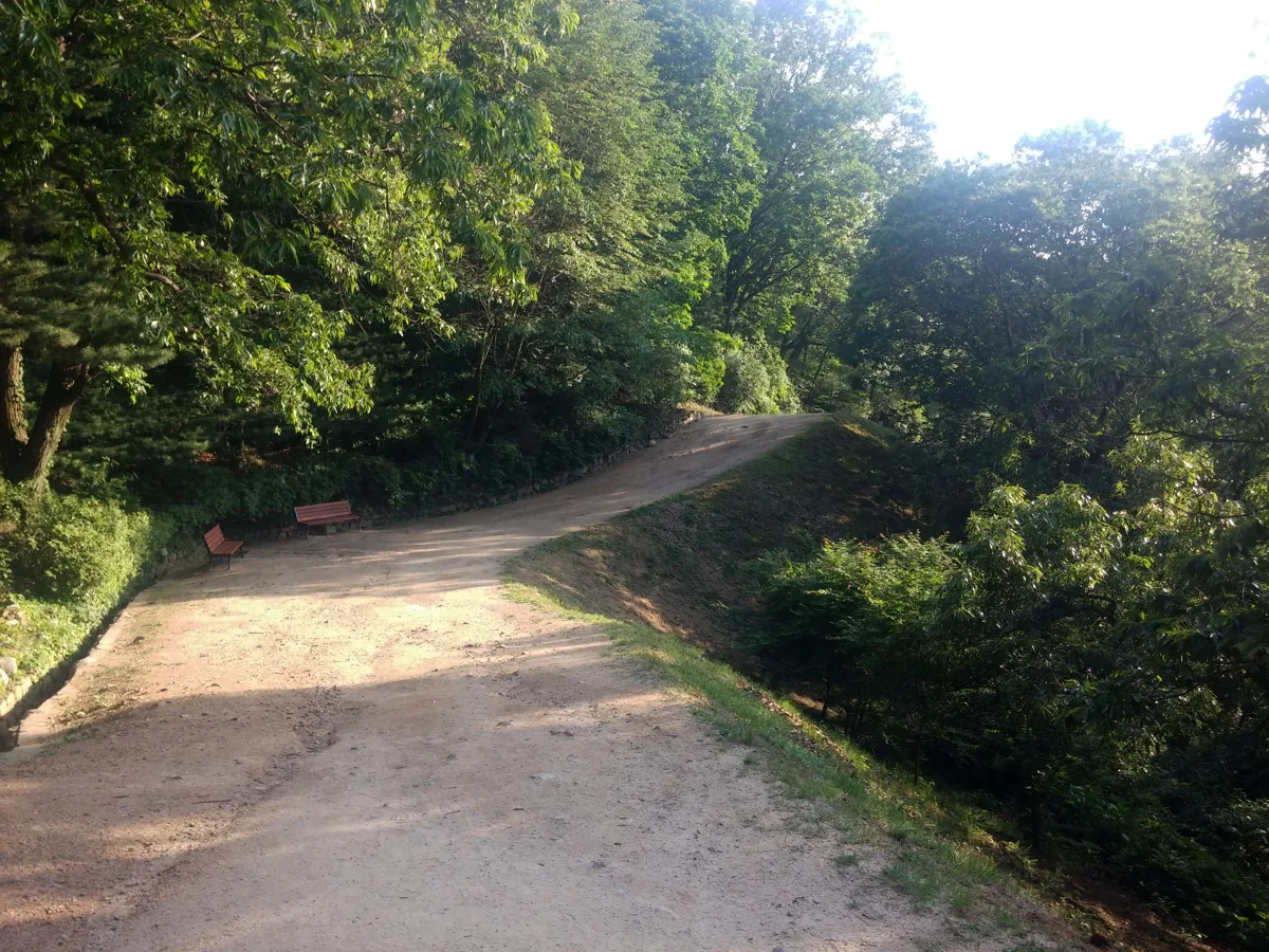 Restored earthen ramparts and a wooded path at Haengjusanseong